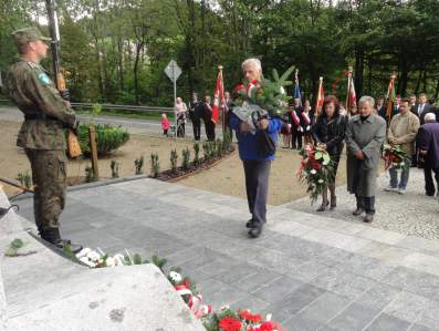 Jan Burek skada kwiaty pod pomnikiem.